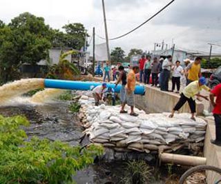 Retiran costales para reducir niveles de agua
